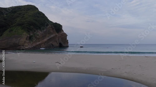 Flying over calm water and crashing waves at Elephant Rock Beach on Tanegashima Island, Japan