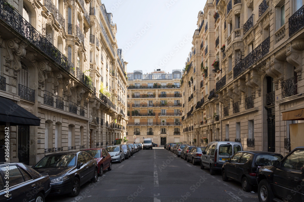 Obraz premium Paris residential street, with Haussmannian facades and parked cars
