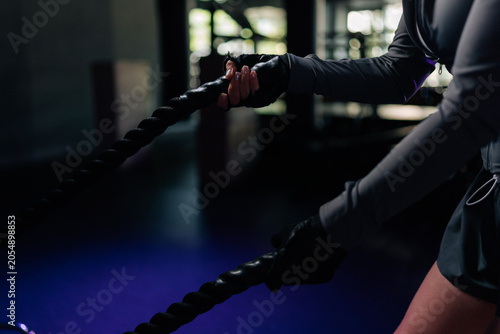 Φωτογραφία Cropped shot of woman hands gripping battle ropes during intense strength training session at gym, focusing on fitness, power, determination through vigorous exercise