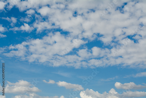 The sky, clouds, changing weather in the blue sky, plumes of smoke gathering into abstract clouds.