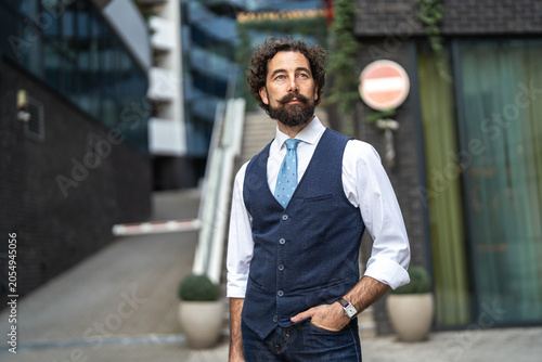 Obraz na plátně Stylish man with beard and mustache in urban setting