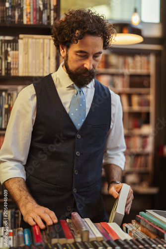 Photography Man choosing book in bookstore aisle