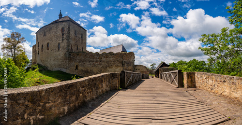 Foto Medieval stone castle with entrance bridge and defensive walls on hilltop