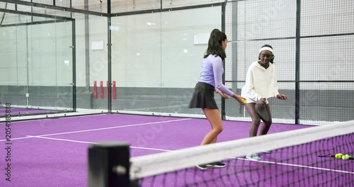 coach and indian trainee feeding, tapping balls on paddle court