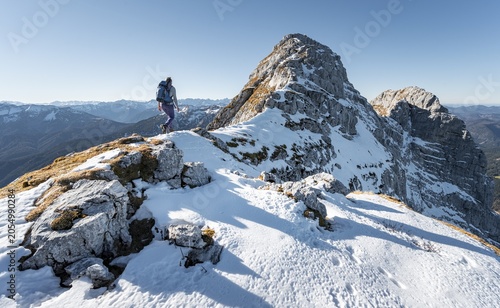 Mountaineer looking over snow-covered mountains, mountain ridge, hiking to Guffert, Brandenberg Alps, Tyrol, Austria
