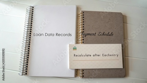 Loan Data Records, Payment Schedule, and Recalculate After Each Entry on a White Wooden Background for Financial Planning