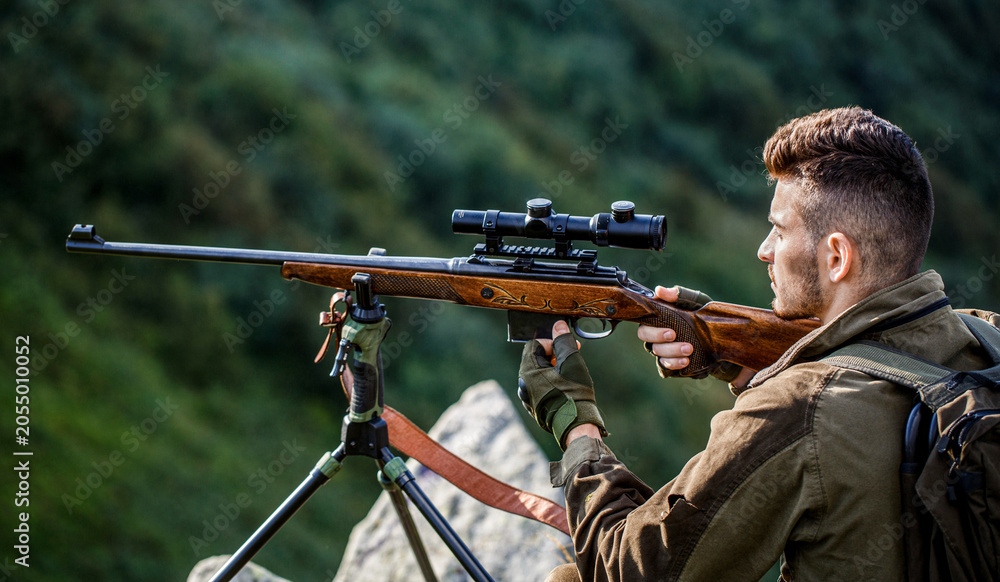 Fototapeta premium Hunting period. Hunter is aiming. The man is on the hunt. Hunter with shotgun gun on hunt. Deer hunt. Hunter in camouflage clothes ready to hunt with hunting rifle. Hunter man