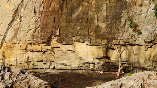 фотографія Powerful Sandstone Cliff Face with Rugged Geological Strata and Weathered Rock F