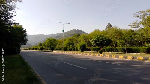 Scenic Empty Road Through Green Landscape with Mountain View and Clear Sky