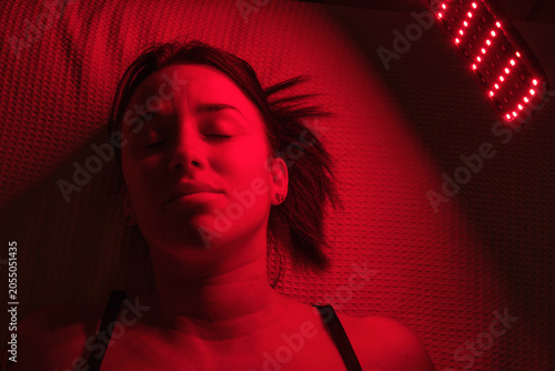 A woman receiving red light therapy for skincare whilst resting