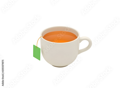 A white teacup with a green tea bag on a black background with orange liquid