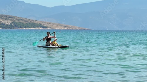 Mother and child paddling on mountain lake
