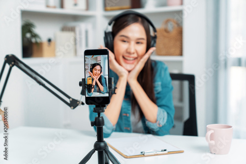Bild auf Leinwand Selective focus phone in host channel of young beautiful Asian in creative broadcaster talking online explaining to promote marketing or consultant in daily life with listener at studio