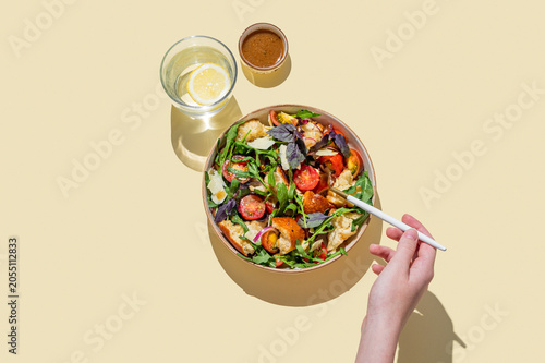 Tuscan panzanella salad with tomatoes, red onion, arugula, basil, cheese and bread in a bowl