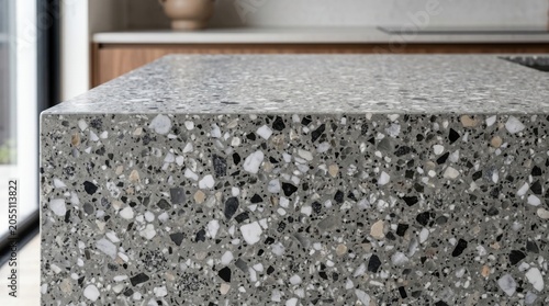 Close-up of premium grey terrazzo kitchen island countertop showcasing detailed stone fragments and marble chips, luxury modern minimalist home interior design with elegant blurred background