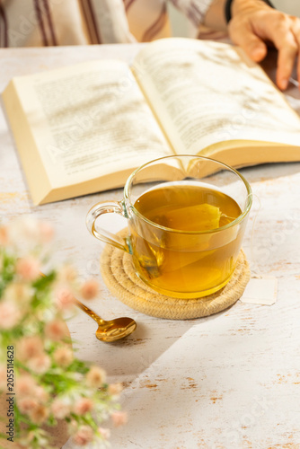 Woman reading book and drinking tea in natural light