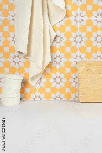 Kitchen counter with white bowls, wooden cutting board, and patterned tile backsplash