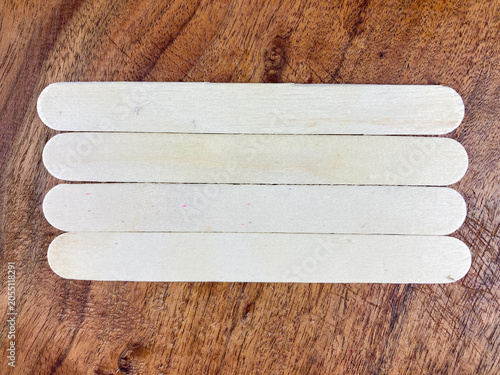 three wooden popsicle stick, four ice cream stick, flat lay of popsicle stick, A top view of three popsicle sticks