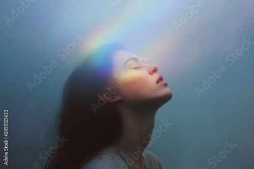 Woman inhaling pure rainbow light with uplifted face for breathwork and mindfulness wallpaper background and spiritual wellness poster