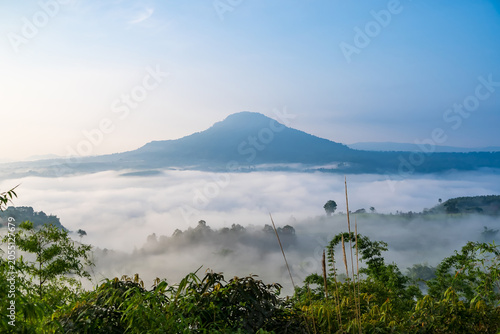 Misty Mountain Sunrise: A breathtaking vista of a dormant volcano shrouded in a sea of mist, illuminated by the soft, ethereal light of dawn.