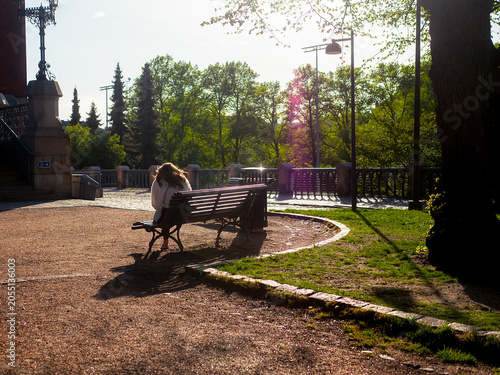 Woman Sitting on a Bench in Evening Sunlight