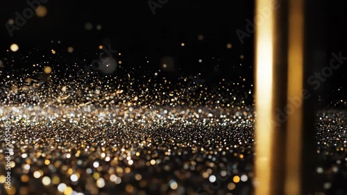 Golden glitter particles shimmer and dance across a dark surface, creating a mesmerizing visual effect with a gradual transition in focus and depth throughout the frames