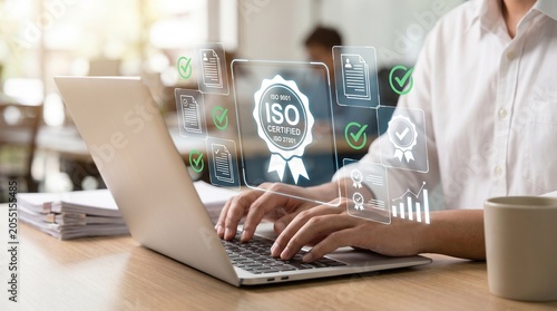 Fotografie Businessperson working on laptop with iso certification compliance overlay