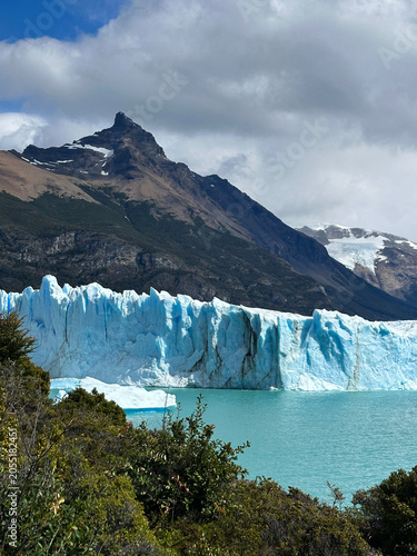 Turquoise waters and towering glacier ice at Perito Moreno Glacier, Patagonia, Argentina. Scenic mountain backdrop, floating icebergs, and pristine wilderness highlight this iconic natural landmark.