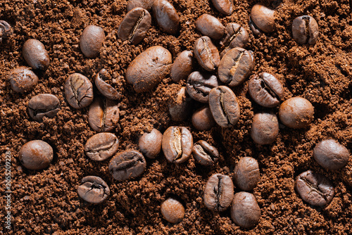 Canvas Print High-Resolution close-up of roasted coffee beans gathered on fresh ground powder