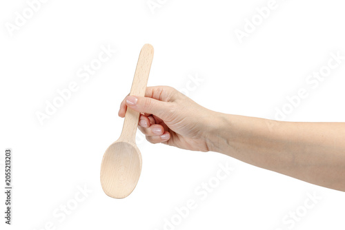 Woman's hand holding a wooden spoon on the white background.