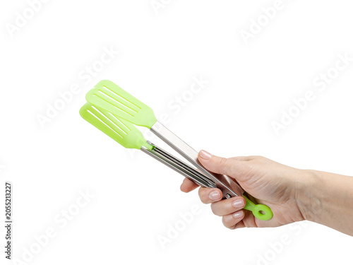 Woman's hand holding a kitchen tongs on the white background.