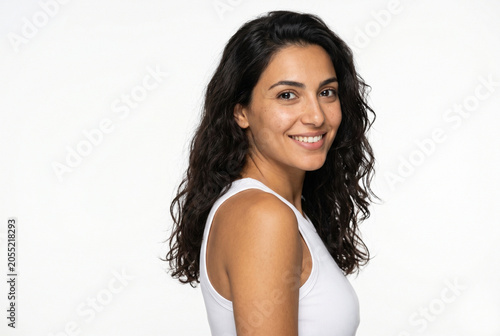 Beautiful brunette woman with wavy hair smiling on white background