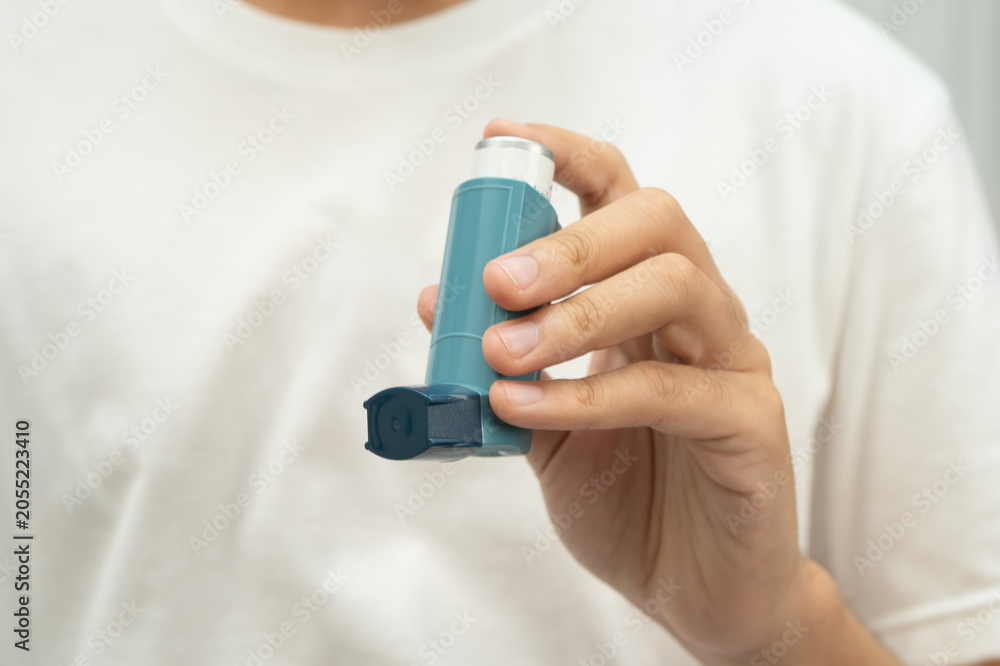 Obraz premium Asthma and chronic obstructive pulmonary disease COPD, Asian teenage using metered dose inhaler MDI.