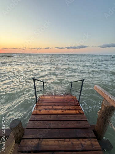 wooden pier with stairway at sunset