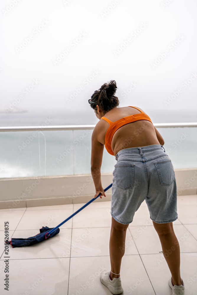 Obraz premium Woman cleaning balcony preparing beach house for summer
