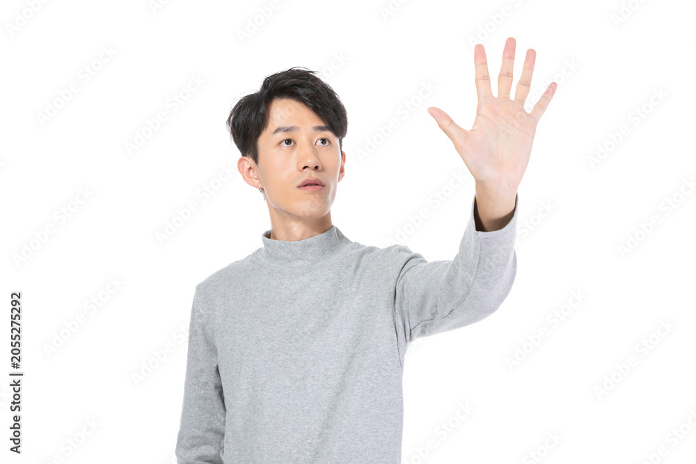Fototapeta premium Young man reaching out to touch an invisible interface