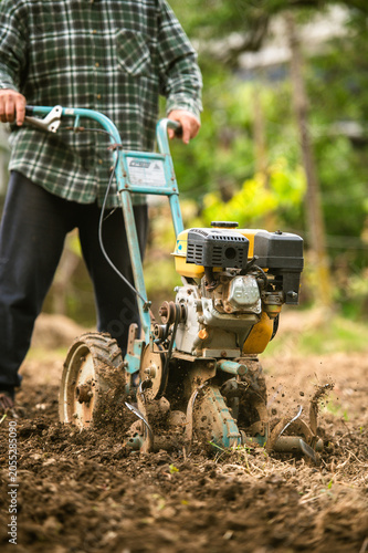 Valokuva Walking behind motor cultivator in garden
