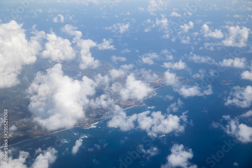 Aerial View of Tropical Caribbean Coastline Through Cumulus Clouds