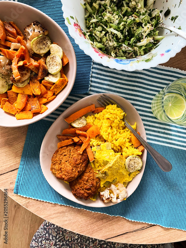Foto A table is set with a colorful meal including rhubarb omelette, turmeric rice, carrot meatballs, roasted vegetables, and a fresh salad