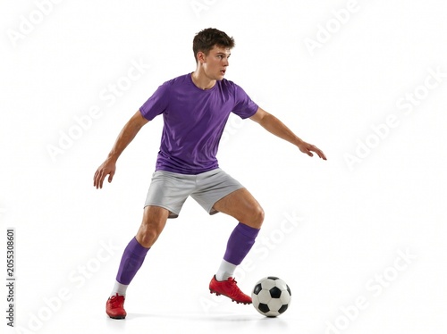 Full Length of Professional Soccer Player Dribbling Ball in Studio Isolated on White Background