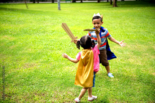 Tableau sur toile Children playing pretend swordfight outdoors.