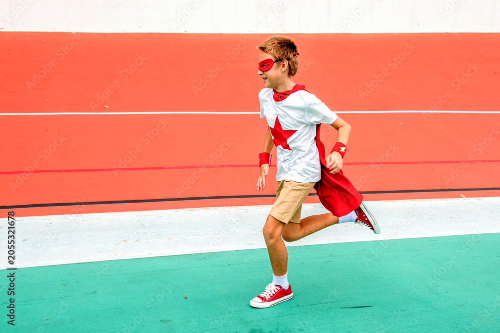 Obraz premium Boy in superhero costume running on a colorful track.