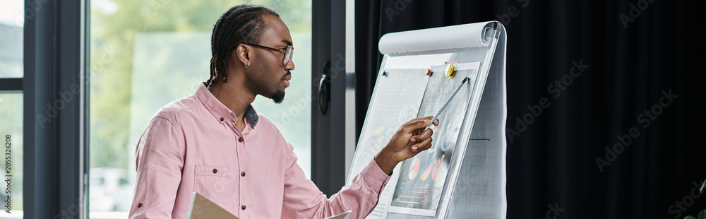 Obraz premium Young African American man presenting ideas in a creative workspace for remote work success