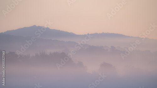 Misty Layered Mountain Ridges at Dawn with Pink Sky