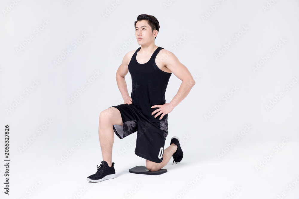 Obraz premium Athletic man doing kneeling lunge stretch warm up in studio