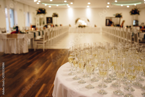Фотография Champagne glasses on table in blurred wedding banquet hall