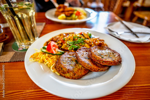 Dining in restaurant, two meal, pancake with meat in sauce, schnitzel, lemonade.