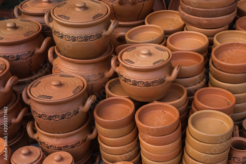 Hand-made ceramic items such as plates and pots are displayed on the counter