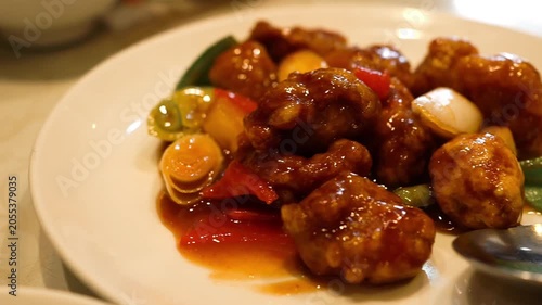 Dining scene at a Chinese restaurant with sweet and sour pork dish