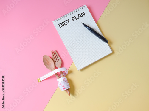 A tape measure wrapped in Wooden fork and spoon,concept of lose weight.